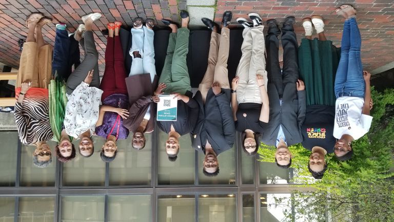 Group of 11 posing for photo outside at the GSU Plaza.