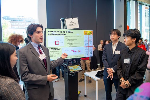Four students are presenting their project at an expo.